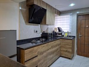 伊巴丹Igbalode Luxury Apartment的厨房配有木制橱柜和黑色台面