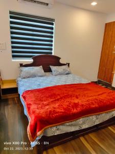 坎努尔Sunshine Service Villa的一间卧室配有一张带红色毯子的大床