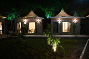 博帕尔The Whispering Palms Resort的夜晚院子里灯火通明的房子