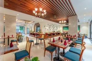 会安Amina Lantana Hoi An Hotel & Spa的餐厅设有木制天花板和桌椅