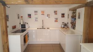 哈斯尔米尔Prestwick Oak - Sleeps 10-14 - Group Accommodation for Family or Friends的厨房配有白色橱柜和水槽