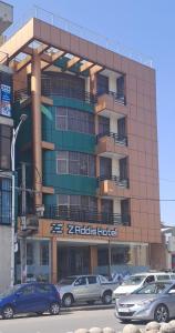 亚的斯亚贝巴Z Addis Hotel的前面有汽车停放的建筑