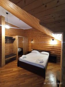 StarychiЯвір Резорт的木制客房内的一间卧室配有一张大床
