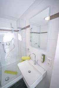 腓特烈港CityApartements FN2-FN4 KLIMATISIERT的白色的浴室设有水槽和淋浴。