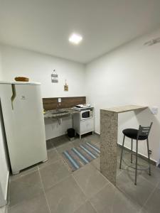 里约热内卢Suite Vargem Grande 2 - praia, cachoeira e trilhas的厨房配有白色冰箱和桌子