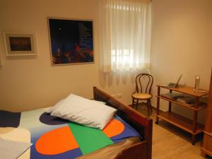 乌迪内AVD - La Nuova Casa di Nonna的一间卧室配有一张床、一张桌子和一把椅子