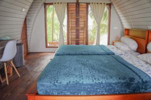 SalulMomos Surf Shack的一间卧室配有一张带蓝色棉被的大床