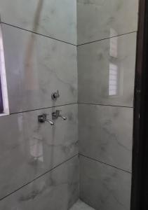 PānīpatPanipat Town House panipath的带淋浴的浴室和玻璃门