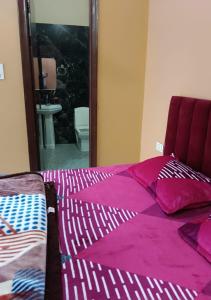 PānīpatPanipat Town House panipath的一间卧室配有一张带紫色床单和镜子的床