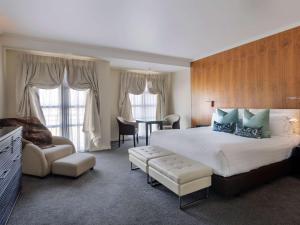 皇后镇皇后镇索菲特酒店及水疗中心的酒店客房设有一张大床和一张桌子。