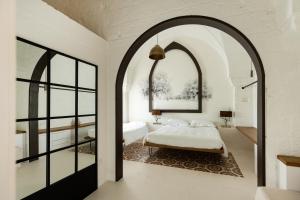 法萨诺AL PALAZZO La Dimora by Apulia Hospitality的拱形客房 - 带一张床和窗户