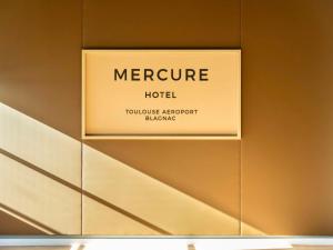 布拉尼亚克Mercure Toulouse Aeroport Blagnac的墙上的酒店标志