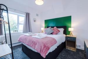 约克Cosy Three-Bedroom House Near City Centre with Free Parking的一间卧室配有一张大床和绿色床头板