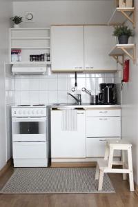 图尔库Norden Homes City Centre 2-Bedroom Apartment + Free Parking的白色的厨房配有炉灶和凳子