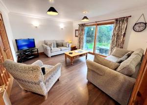 克里安拉利Stob Binnein Cottage的客厅配有两张沙发和一台电视机