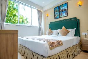 马累Hotel Flora Inn Male Maldives的一间卧室设有一张大床和大窗户