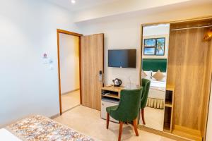 马累Hotel Flora Inn Male Maldives的酒店客房设有书桌和卧室。