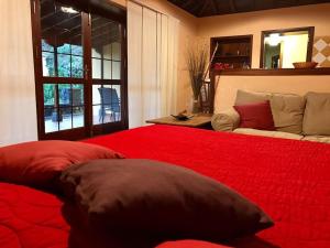 下布雷尼亚RUSTIC HOUSE LA MONTAÑA的一间卧室配有一张红色的大床和一张沙发