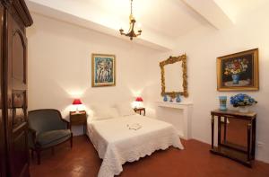 马莱莫尔拉麦迅派恩特雷普罗旺斯酒店的一间卧室配有一张床、一把椅子和镜子