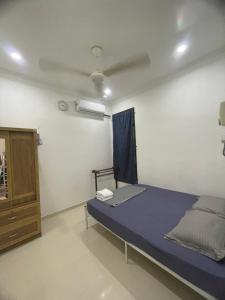 Kampong Tanjong GelamHomestay Cendana Gong Badak的一间卧室配有一张床和一个橱柜