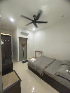 Kampong Tanjong GelamHomestay Cendana Gong Badak的一间卧室配有一张床和吊扇