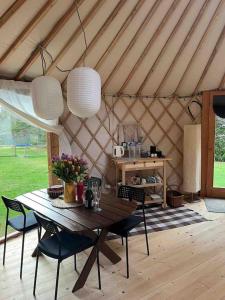 奥赫里姆Aughavannagh Yurt Glamping的圆顶帐篷内的木桌,配有桌椅