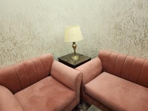 吉达EWG Al Hamra Hotel的两张棕色皮沙发,坐在桌子旁,带灯