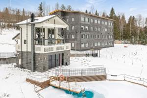 沃卡蒂Vuokatti Booking Suites的建筑物前的雪地建筑