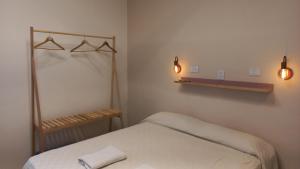 拉法尔达Holâ Hotel的卧室配有一张床,墙上有两盏灯