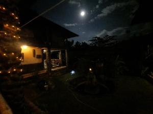 公主港Bambua Nature Cottages的天空中月亮的夜晚房屋