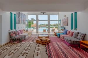 赫尔格达Stunning Villa for Rent in El Gouna HEATED PRIVATE POOL的客厅配有色彩缤纷的家具和游泳池