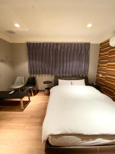 Saijō-chōHotel JOYCE的卧室设有一张白色大床和一扇窗户。