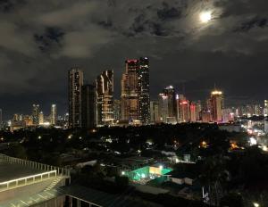 马尼拉Condo with Balcony at Makati SM Jazz的夜空月亮的城市天际线