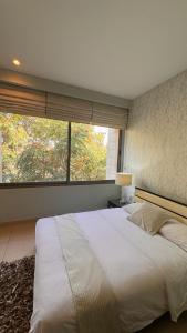 安曼Abdoun Falls Luxury Apartment的一间卧室设有一张大床和一个大窗户