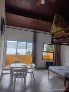 伊利亚贝拉Chalé do Saulo的客房设有桌椅和窗户。