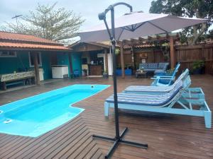 帕罗卡Pousada Inn Nature的一个带2把躺椅和遮阳伞的游泳池