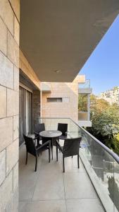 安曼Abdoun Falls Luxury Apartment的阳台的天井配有桌椅
