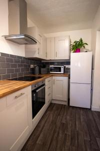 格兰瑟姆Fully renovated spacious home, Sleeps 5,的厨房配有白色橱柜和白色冰箱。