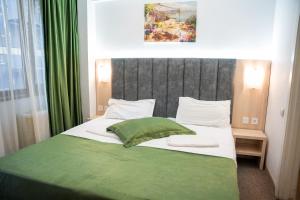 布加勒斯特坎泰米尔酒店的一间卧室配有一张带绿毯的大床