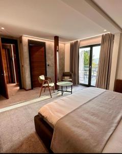 莱斯拉塞斯Hôtel Restaurant & Spa Les Planets的一间卧室配有一张大床和一张桌子