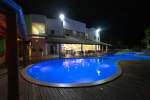 利尼亚雷斯BHS酒店的一座大型蓝色游泳池,在晚上在大楼前