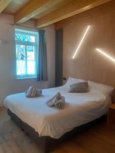 圣维托-迪卡多雷Appartamento Vale e Schena Cortina D'Ampezzo的一间卧室配有一张大床和毛巾