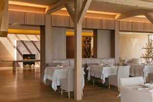 拉纳维吉露斯山度假酒店的餐厅设有白色的桌椅和壁炉