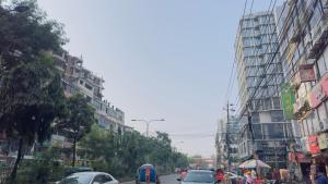 达卡Hotel New Royal Palace Dhanmondi的一条繁忙的城市街道,路上有汽车和人