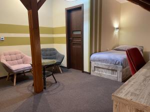 科内日诺河畔里赫诺夫Hotel Herman的卧室配有1张床、1张桌子和1把椅子