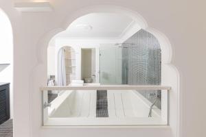 卡普里马美拉酒店的白色的浴室设有浴缸和镜子