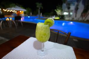 利尼亚雷斯BHS酒店的坐在游泳池旁的桌子上享用一杯绿色饮料