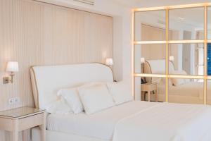 卡普里马美拉酒店的白色的卧室配有白色的床和镜子