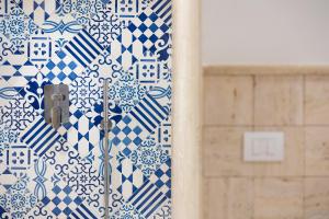 卡普里马美拉酒店的浴室的墙壁上铺有蓝色和白色的瓷砖