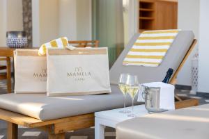 卡普里马美拉酒店的一张桌子,上面有一张床垫和一杯葡萄酒